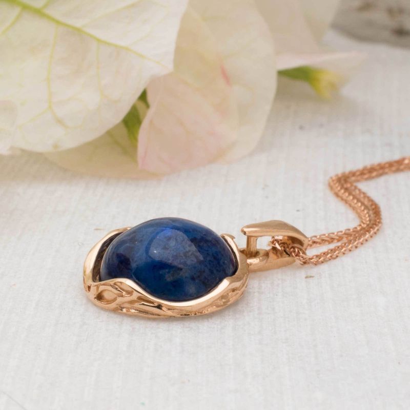 Кулон из красного золота с лазуритом, украшенный кабошоном.