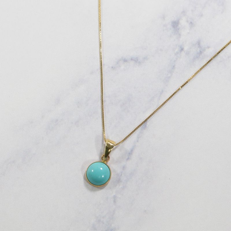 Круглый кулон из 14-каратного золота с искусственной бирюзой.