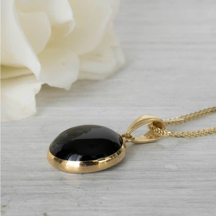 Круглый кулон из 14-каратного золота с ониксом.
