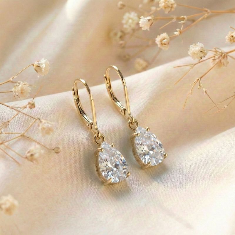 Позолоченные серьги-подвески в виде штанги с инкрустацией цирконием.