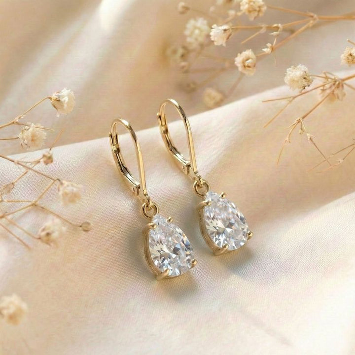 Позолоченные серьги-подвески в виде штанги с инкрустацией цирконием.