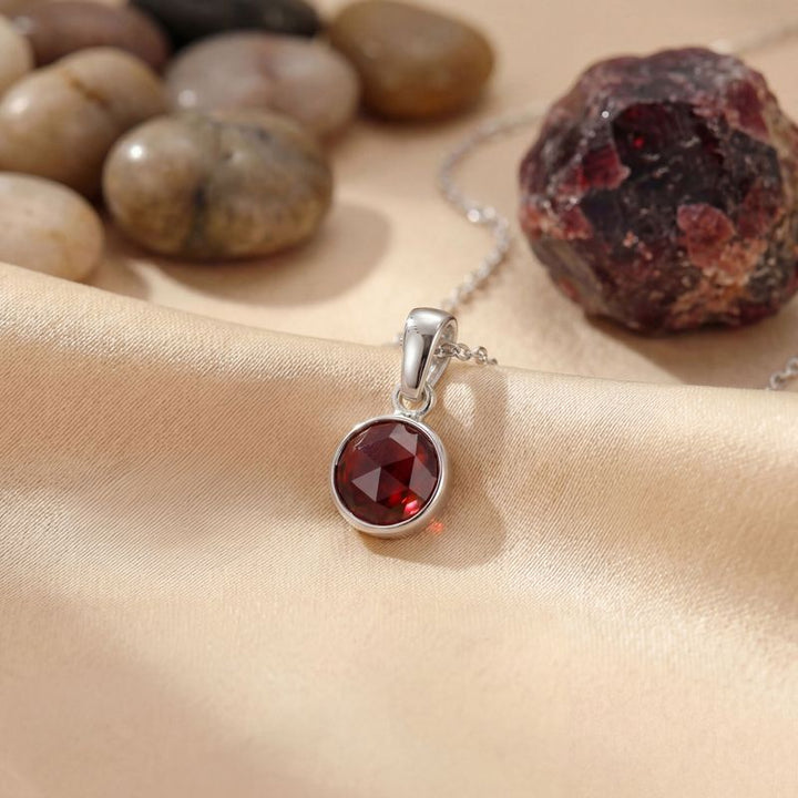 Круглый кулон из 14-каратного золота с гранатом.